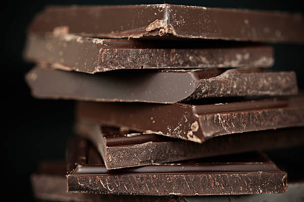 Broken squares of dark chocolate on a white surface