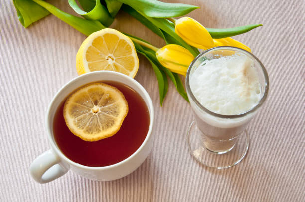 Fresh lemon halves and whole lemons on a white surface