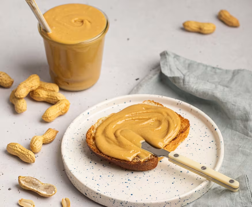 Jar of peanut butter with a wooden spoon
