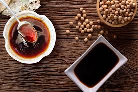 Bottle of soy sauce with chopsticks on a wooden surface